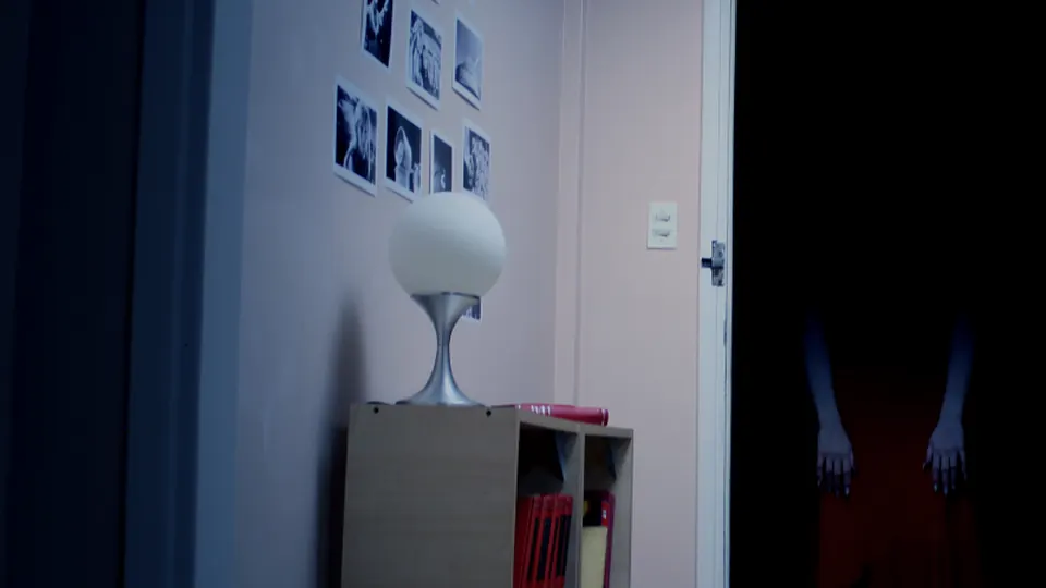 Wooden shelf and lamp beside a dark open doorway